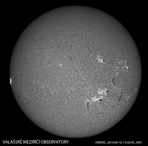 Celkový snímek Slunce se zachycenou erupcí (vlevo na okraji disku). Snímek byl pořízen dne 10. 6. 2014 ve 13:02:45 UT.