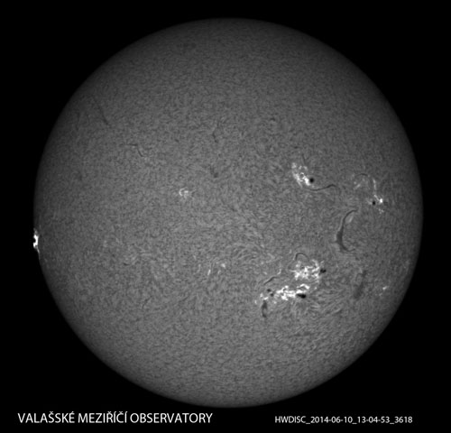 Celkový snímek Slunce se zachycenou erupcí (vlevo na okraji disku). Snímek byl pořízen dne 10. 6. 2014 ve 13:04:53 UT. Jsou již patrny zárodky formujících se poerupčních smyček.