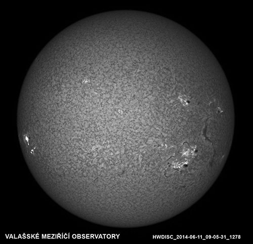 Snímek Slunce v čáře H-alfa ze dne 11. 6. 2014 v 09:05:31 UT. Kromě aktivních oblastí a velkého filamentu na západní části disku zobrazuje také erupci na východním okraji.