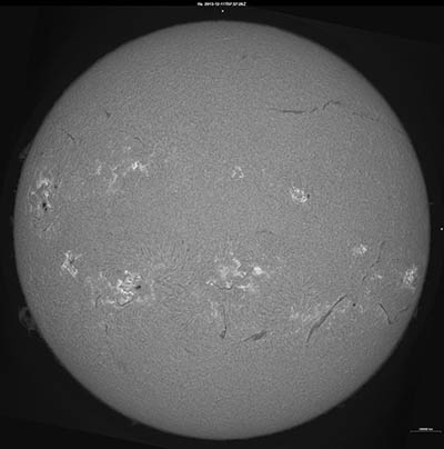 Obr. 3: Snímek celého slunečního disku ve chromosférické spektrální čáře Hα. Kromě špatně viditelných slunečních skvrn jsou zde na slunečním okraji vidět protuberance, na disku pak filamenty a v aktivních oblastech zjasnění, která mohou přecházet až do erupcí.
