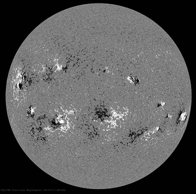 Obr. 5: Na snímku podélné složky magnetického pole z družice SDO vidíme jeho reálnou strukturu s rozlišenou polaritou. Protože snímky na obr. 1 – obr. 6 byly pořízeny tentýž den (11. 12. 2013), můžeme jejich struktury navzájem porovnávat.