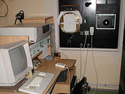 Obr. 19: Stanoviště pozorovatele před vstupní štěrbinou spektrografu. Z levé strany řídící počítače, nastavovací prvky magnetografu a zcela vzadu u zdi stokesmeter. Vstupní štěrbina do spektrografu je uprostřed disku, na čelní stěně místnosti, přikrytá papírem.